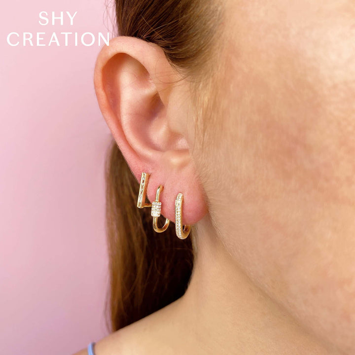 Shy Creation 0.18 ct Diamond Oval Hoop Earrings in 14K Yellow Gold — styled with other jewellery; additional pieces sold separately — SC55023239H0.65