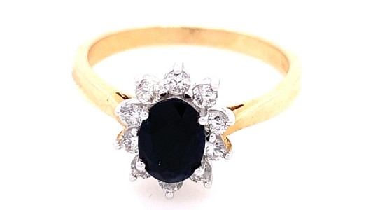 a mixed metal statement ring featuring an oval cut black center stone